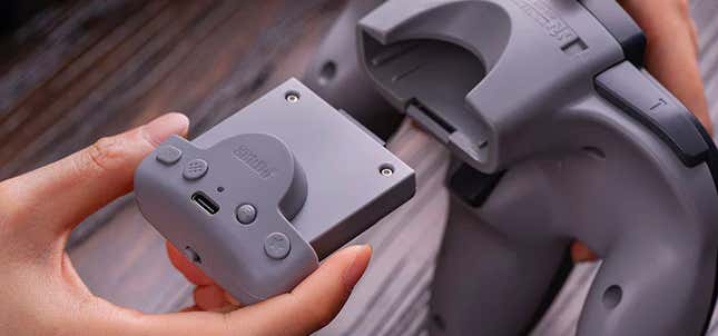 The upgraded 8BitDo Rumble Pack being inserted into an original N64 controller.