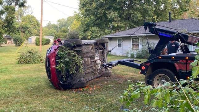 Car on its side near house after being hit with wheel