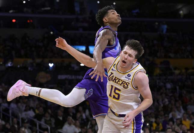 Apr 9, 2023; Los Angeles, California, USA;  Los Angeles Lakers guard Austin Reaves (15) is fouled by Utah Jazz guard Ochai Agbaji (30) as he drives for a basket in the first half at Crypto.com Arena.