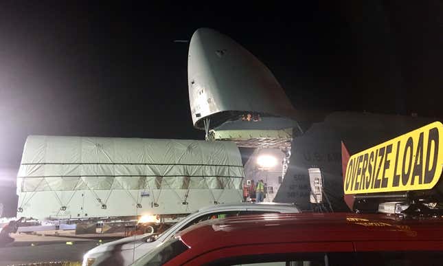 The satellite is completely out of the C-5 as its convoy prepares to depart.