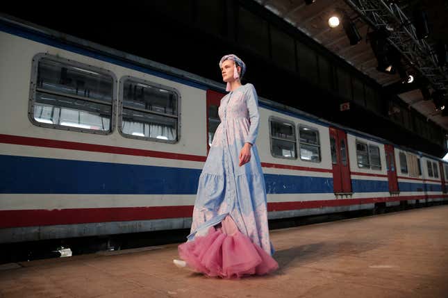 A model hits the catwalk of a fashion show during the International Modest Fashion Week, in Istanbul, Friday, May, 13, 2016. Turkeys first International Modest Fashion Week has opened in Istanbul bringing designers and models of conservative wear from around the world. The two-day event kicked off Friday with models hitting the runway at a historic train station donning a bright palette of breezy garment and kaleidoscopic headscarves. (AP Photo/Lefteris Pitarakis)