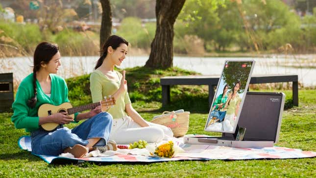 Dos personas en un parque haciendo un picnic usando el nuevo LG StanbyME para reproducir música.