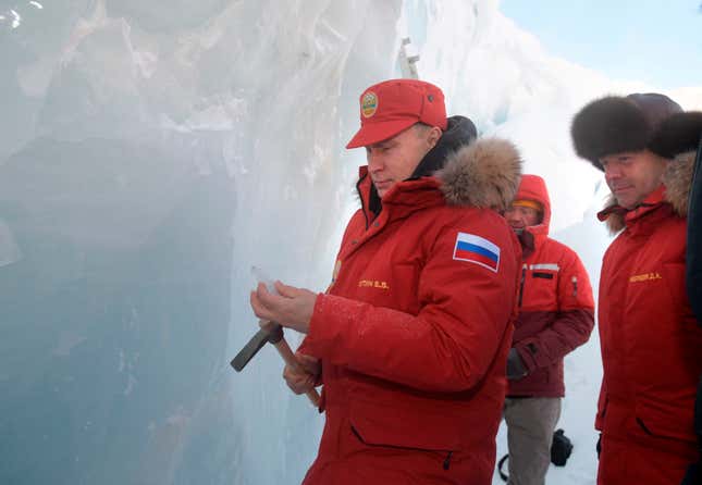 Putin digs out a piece of ice with an ice pick. (AP via pool/Sergei Karpukhin)