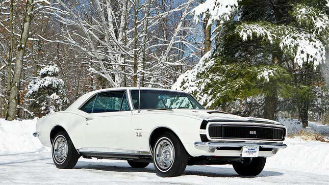 A photo of a white Chevrolet Camaro in the snow. 