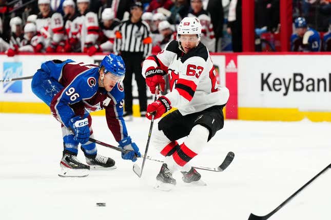 Mar 1, 2023; Denver, Colorado, USA;New Jersey Devils left wing Jesper Bratt (63) passes the puck away from Colorado Avalanche right wing Mikko Rantanen (96) in the first period at Ball Arena.