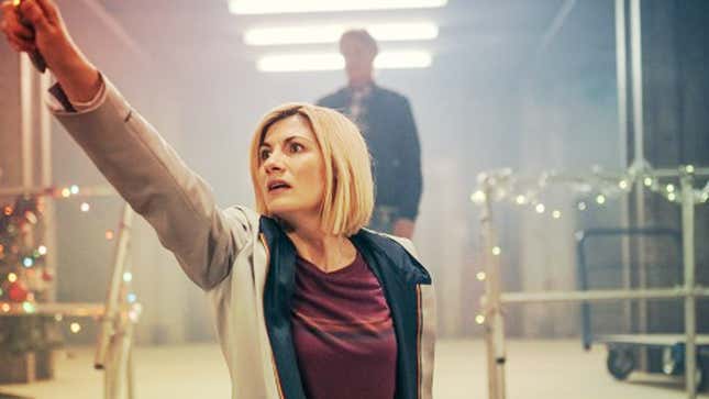 Jodie Whittaker's 13th Doctor raises her sonic screwdriver up to the air with a worried expression.