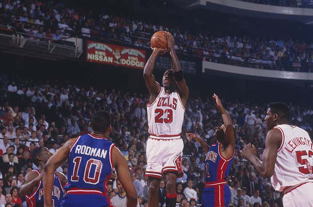 Michael Jordan #23 of the Chicago Bulls jumps to shoot a basket against the Detroit Pistons as Cliff Levingston #53 of the Bulls, Dennis Rodman #10 of the Pistons and Isiah Thomas #11 of the Pistons watch the shot at the Chicago Stadium during the 1991 NBA Playoffs in Chicago, Illinois.
