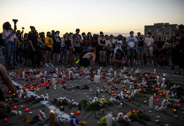 MINNEAPOLIS, MN - JUNE 04: People place flowers during a vigil at the site where Winston Boogie Smith was killed on June 4, 2021 in Minneapolis, Minnesota. Smith was shot and killed yesterday during an altercation with law enforcement involving multiple agencies. 