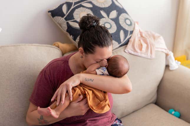 A woman cuddles her newborn in New York, 2023.