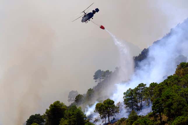  A helicopter battles a blaze in Alhaurin de la Torre, Malaga, Spain, Saturday, July 16, 2022.