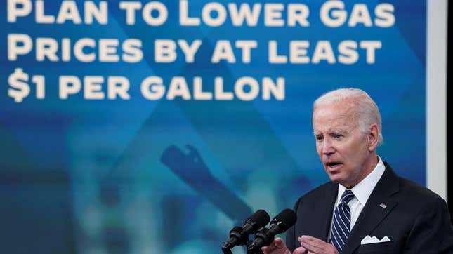 President Joe Biden speaks into a microphone, with the words "Plan to lower gas prices by at least $1 per gallon" projected behind him.