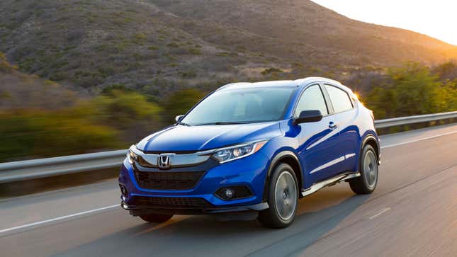 A photo of a blue Honda HR-V crossover driving on a highway. 