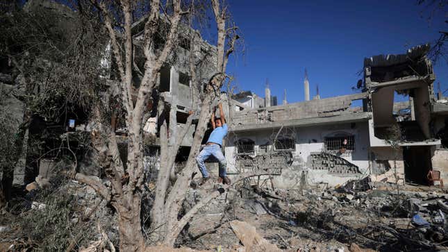  Palestinian boy plays on May 24, 2021 next to buildings damaged damaged by Israeli air strikes earlier this month in Beit Hanoun in the northern Gaza Strip.