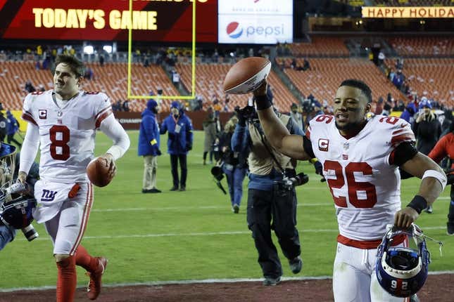 Dec 18, 2022; Landover, Maryland, USA; New York Giants quarterback Daniel Jones (8) and Giants running back Saquon Barkley (26) celebrate while leaving the field after their game against the Washington Commanders at FedExField.