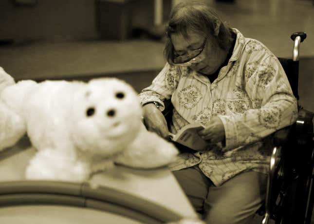 A resident reads a book during a session Paro at Shin-tomi nursing home in Tokyo, Japan.