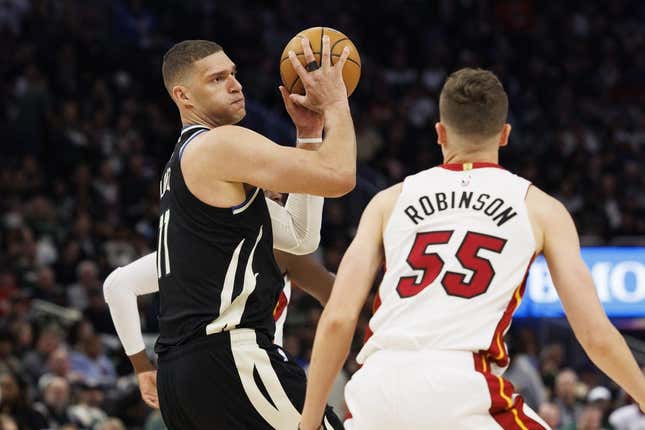Apr 19, 2023; Milwaukee, Wisconsin, USA; Milwaukee Bucks center Brook Lopez (11) holds the ball away from Miami Heat guard Duncan Robinson (55) during the fourth quarter during game two of the 2023 NBA Playoffs at Fiserv Forum.