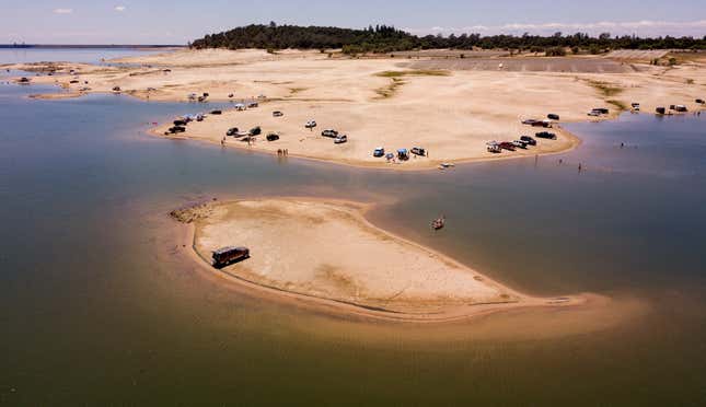 A vehicle is parked on a newly revealed piece of land due to receding waters at the drought-stricken Folsom Lake in Granite Bay, California on May 22, 2021.