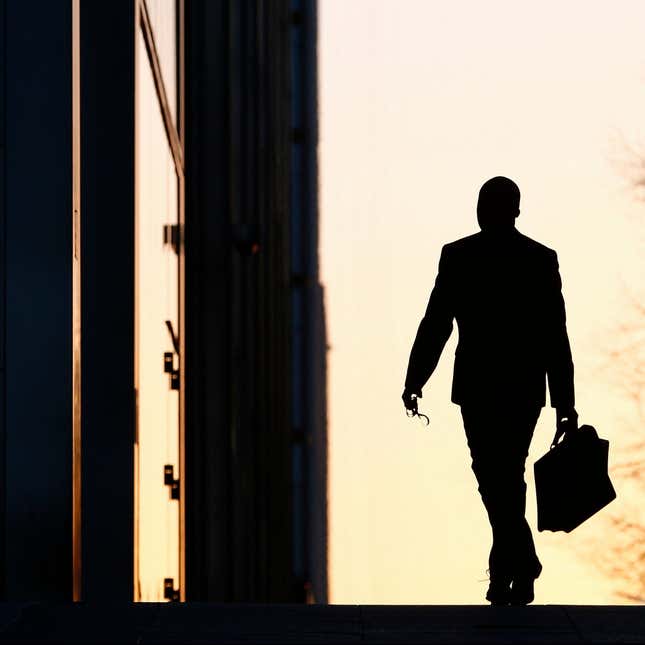 A worker arrives at his office in the Canary Wharf business district in London February 26, 2014.