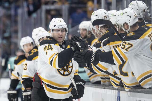 Feb 23, 2023; Seattle, Washington, USA; Boston Bruins forward Jake DeBrusk (74) is congratulated by teammates on the bench during the third period against the Seattle Kraken at Climate Pledge Arena.
