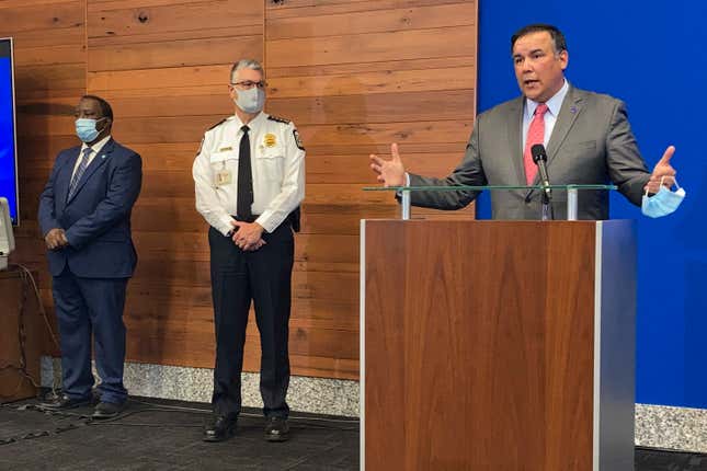 In this April 21, 2021 file photo, Columbus Mayor Andrew Ginther, right, speaks during a news conference in Columbus, Ohio, announcing technical assistance from the Justice Department in the wake of allegations misconduct in the city’s police department. A Black woman officer just won her racial discrimination lawsuit against the force.