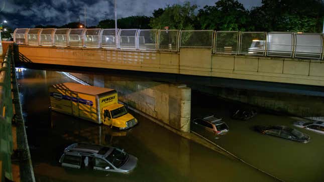 Floodwater surrounds vehicles following heavy rain on an expressway in Brooklyn, New York early on September 2, 2021, as flash flooding and record-breaking rainfall brought by the remnants of Storm Ida swept through the area. 