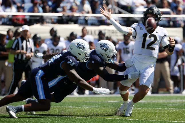 Sep 16, 2023; Norfolk, Virginia, USA; Wake Forest Demon Deacons quarterback Mitch Griffis (12) fumbles the ball while being tackled by Old Dominion Monarchs defensive end Amorie Morrison (4) and linebacker EJ Green (24) during the second quarter at Kornblau Field at S.B. Ballard Stadium.