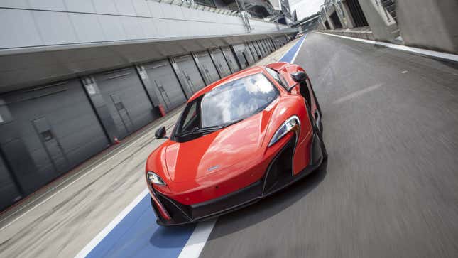 A photo of a red McLaren 675LT driving down the pit lane at Silverstone. 