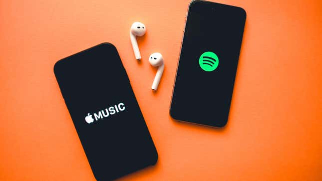 Two phones with screenshots of apple music and spotify logos 