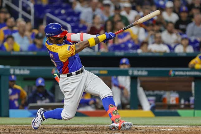 Mar 18, 2023; Miami, Florida, USA; Venezuela center fielder Ronald Acuna Jr. (42) hits a double during the eighth inning against the USA at LoanDepot Park.