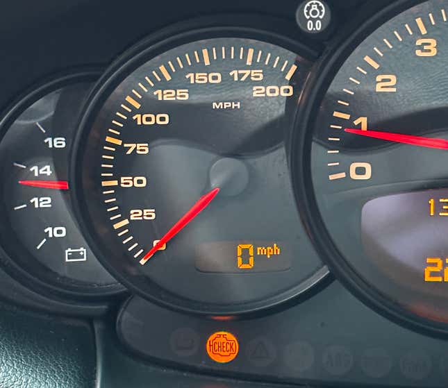 The gauge cluster of a 996-generation 2003 Porsche 911 with a check engine light lit.