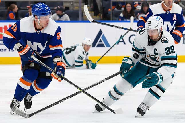 Oct 18, 2022; Elmont, New York, USA; San Jose Sharks center Logan Couture (39) and New York Islanders center Casey Cizikas (53) battle for a loose puck during the third period at UBS Arena.