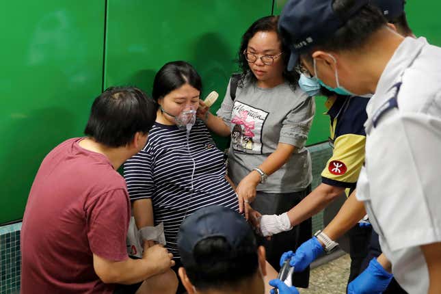 Workers comfort a pregnant woman as protesters disrupt subway service at Fortress Hill MTR station in Hong Kong, Aug. 5, 2019.