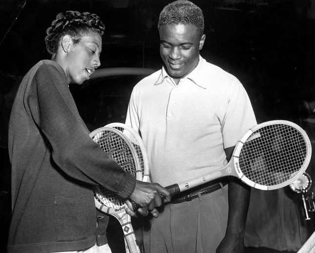 Tennis great Althea Gibson shows baseball legend Jackie Robinson her backhand grip on February 16, 1951 at the ANTA Theater Tennis Tournament in Manhattan.