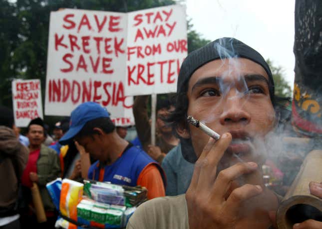 A protester smokes a “kretek” during a rally demanding the US government lift a federal law banning flavored cigarettes, outside the US embassy in Jakarta, Indonesia on May 31, 2012.