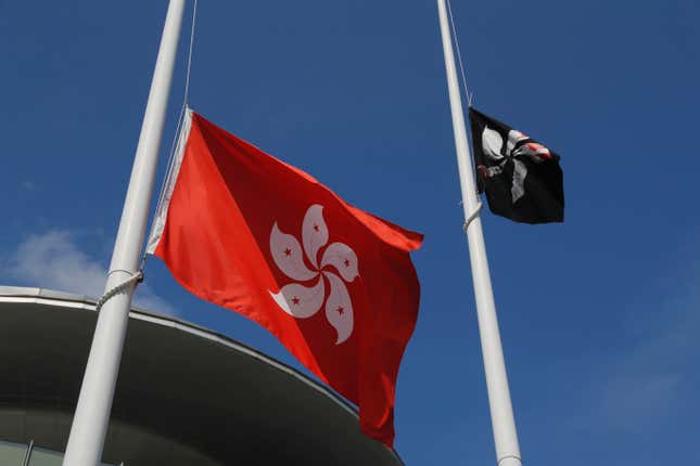 Activists raise a black version of the Hong Kong bauhinia flag.