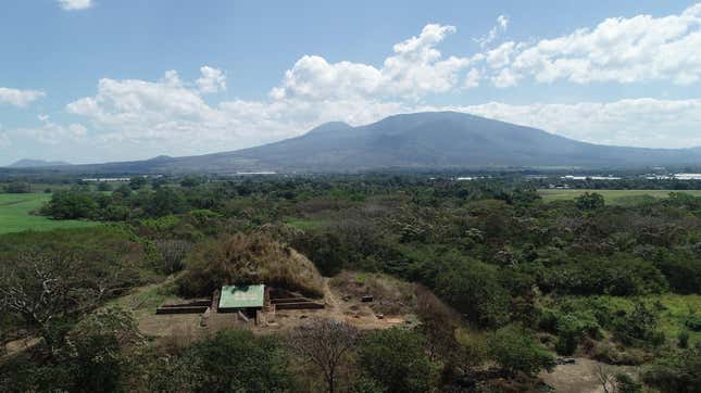 The pyramid, known as the Campana structure, with volcanic mountains in the background. 