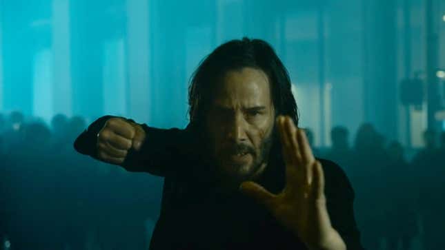 Keanu Reeves takes a martial arts stance while surrounded by enemies.