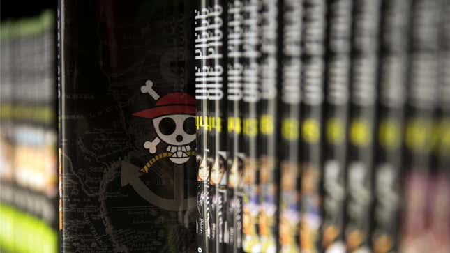 Pictured is a row of One Piece manga with one issue pulled out, showing the One Piece skull and bones symbol.  