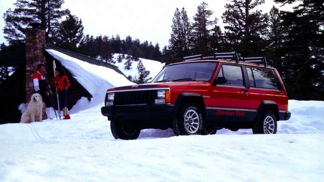 A photo of a red Jeep XJ SUV parked on snow. 