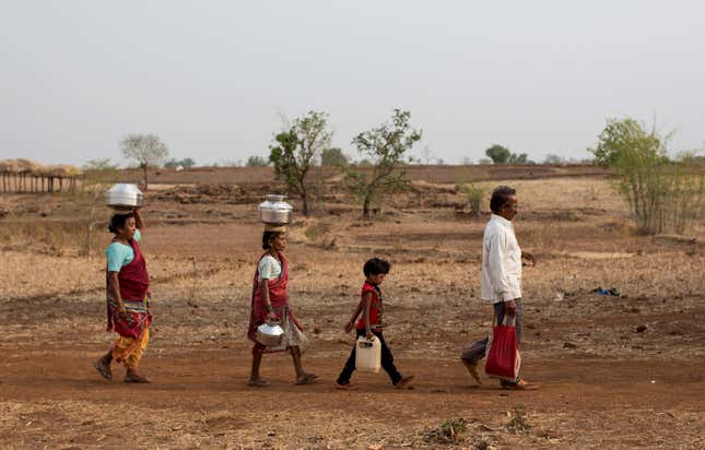 Bhaagi (L) and Sakhri (2nd from L), wives of Sakharam Bhagat (R) walk to fetch water from a well