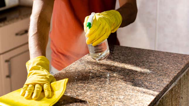 Man cleaning kitchen counters.
