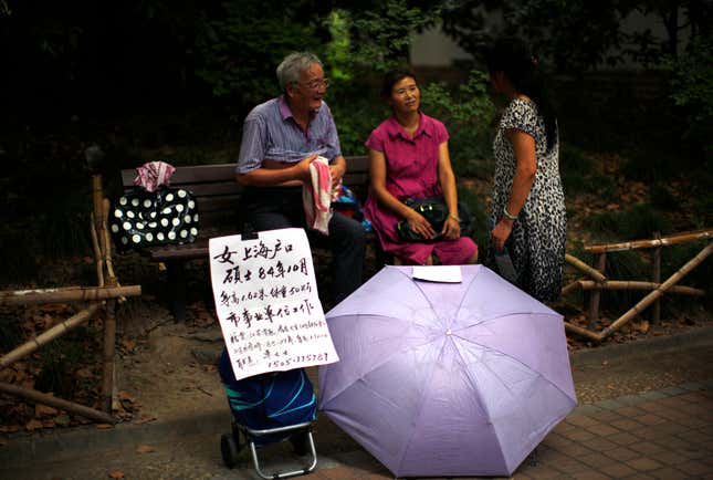Parents hold up a sign listing their single daughter’s age, height, weight, and phone number.