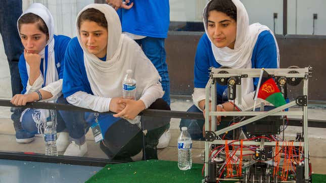 Members of the Afghan all-girls robotics team, with their robot nearby, watch the robots of other countries in the practice area on July 17, 2017 in Washington, D.C. 