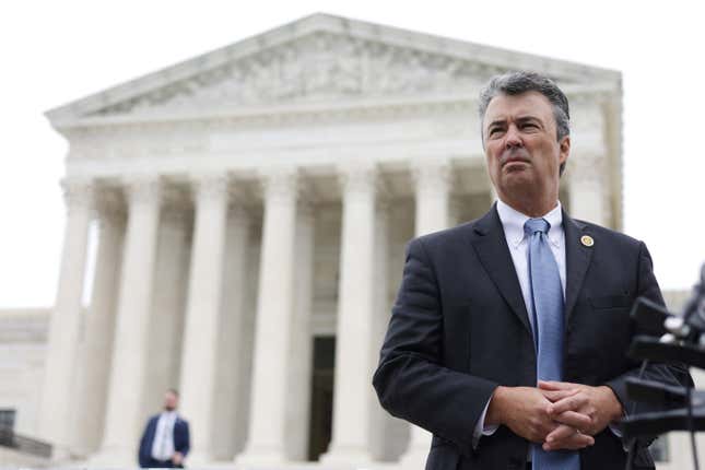 Alabama attorney general Steve Marshall stands outside the Supreme Court with his hands clasped in front of him, and gazing squinting off into the distance.