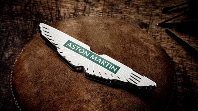 A photo of the new Aston Martin enamel badge on a brown leather surface. 