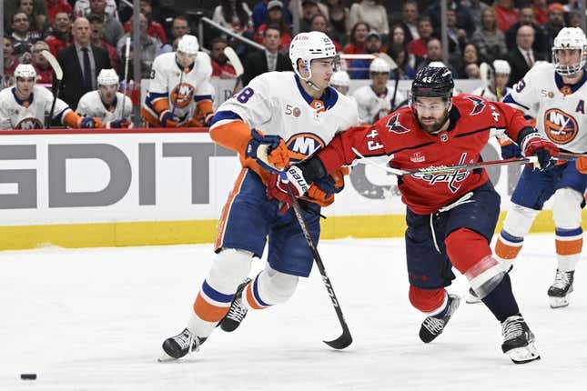 Mar 29, 2023; Washington, District of Columbia, USA; New York Islanders defenseman Alexander Romanov (28) and Washington Capitals right wing Tom Wilson (43) battle for the puck during the first period at Capital One Arena.