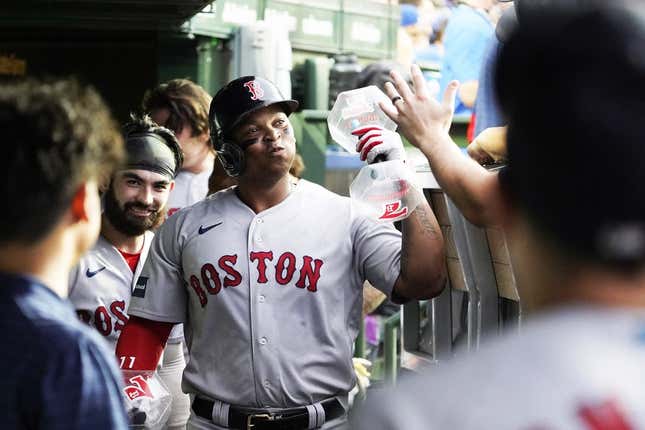 Jul 14, 2023; Chicago, Illinois, USA; Boston Red Sox third baseman Rafael Devers (11) celebrates with teammates in the dugout after hitting a home run against the Chicago Cubs during the third inning at Wrigley Field.