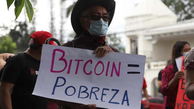A man holds a sign that reads in Spanish: “bitcoin  equals poverty,” in San Salvador, El  Salvador on Sept. 1, 2021.