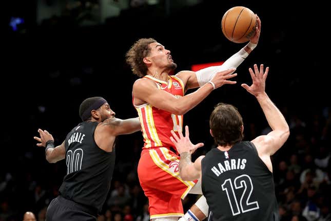 Mar 31, 2023; Brooklyn, New York, USA; Atlanta Hawks guard Trae Young (11) drives to the basket against Brooklyn Nets forwards Royce O&#39;Neale (00) and Joe Harris (12) during the second quarter at Barclays Center.