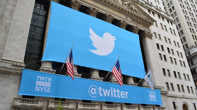 A banner above the New York Stock Exchange with the Twitter logo and the word @twitter below it.